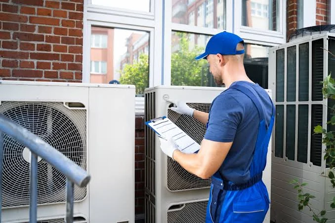 HVAC technician inspecting residential outdoor equipment with a service checklist